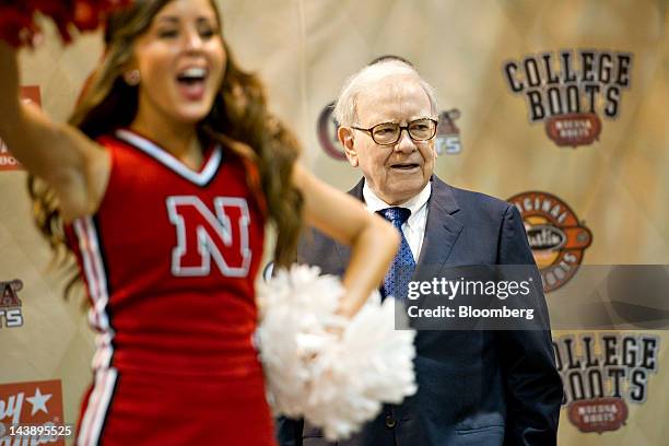 Warren Buffett, chairman of Berkshire Hathaway Inc., listens as cheerleaders from the University of Nebraska cheer during an event at the Berkshire...