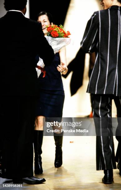 Designer Cynthia Rowley accepts a bouquet of flowers on the runway at show finale.