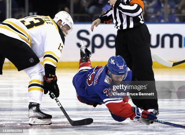 Charlie Coyle of the Boston Bruins trips up Ryan Carpenter of the New York Rangers off the second period opening faceoff at Madison Square Garden on...