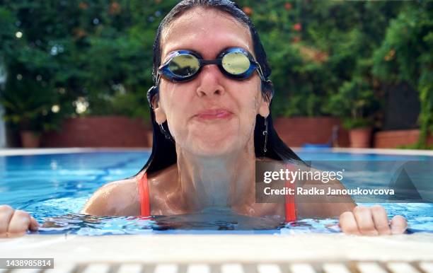 sports woman emerging out of water in a swimming pool with goggles - simglasögon bildbanksfoton och bilder