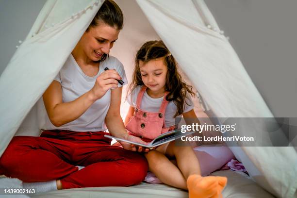 mother reading a story to her daughter - electric torch stock pictures, royalty-free photos & images