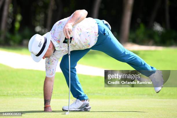 Rory Sabbatini of Slovakia picks his ball from the 18th hole after making a double bogey and complaining to spectator for the noise during the second...