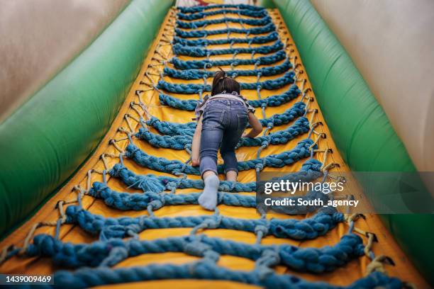 kleines mädchen spielt in hüpfburg - inflatable playground stock-fotos und bilder