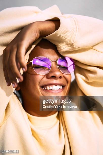 happy and beautiful hipster millennial woman smiling to the sun wearing purple glasses - cool sunglasses stock pictures, royalty-free photos & images