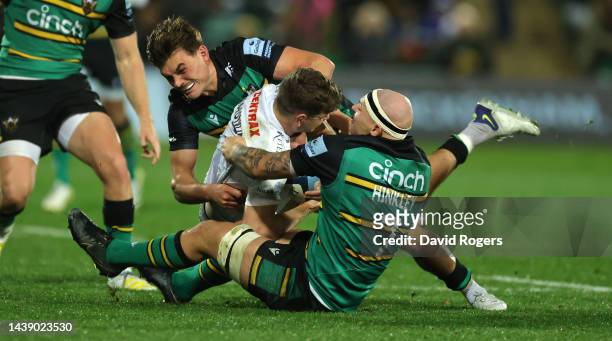 Jack Maunder of Exeter Chiefs is tackled by Aaron Hinkley and George Furbank during the Gallagher Premiership Rugby match between Northampton Saints...