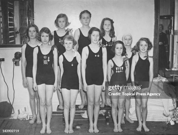 Princess Elizabeth with the rest of the Challenge Cup swimming team at the Bath Club, 34 Dover Street, London, 28th June 1939. Back row, left to...