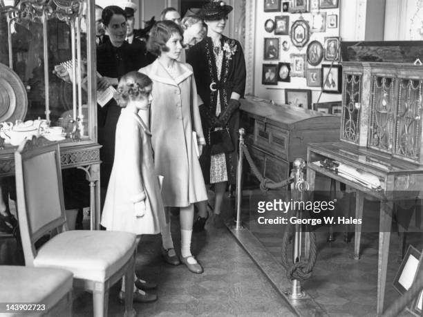 Princesses Elizabeth and Margaret at an exhibition of royal treasures at 145 Piccadilly, London, 28th July 1939. On the right is Elizabeth's...