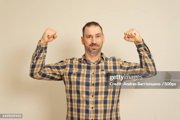 caucasian happy unshaven strong 40 year old man in plaid shirt showing - 40 year old male face stockfoto's en -beelden