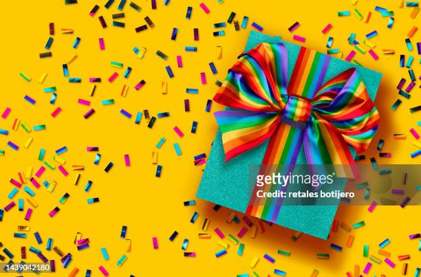 gift boxes wrapped with a rainbow bow - rainbow confetti stock pictures, royalty-free photos & images