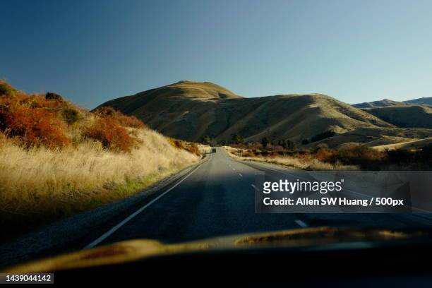 empty road along landscape against clear sky,lindis pass,otago,new zealand - allen sw huang stock pictures, royalty-free photos & images