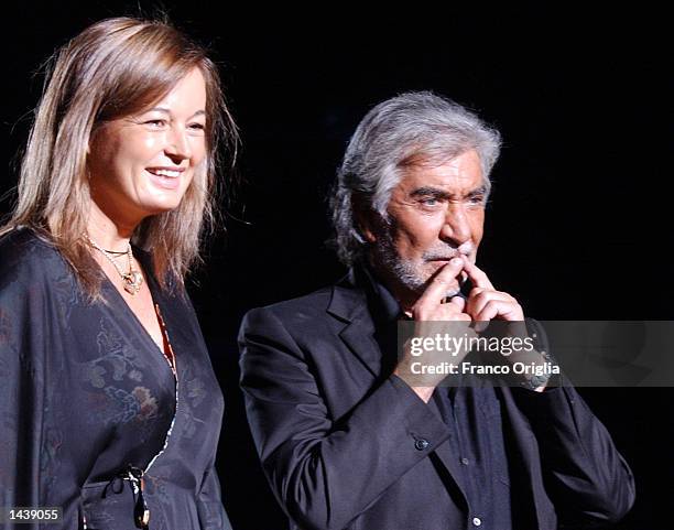 Italian designer Roberto Cavalli and his wife acknowledges the applause at the end of his Spring/Summer women's collection for 2003 September 30,...