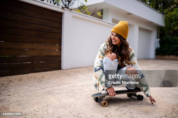 young adult woman skateboarding - woman longboard stock pictures, royalty-free photos & images