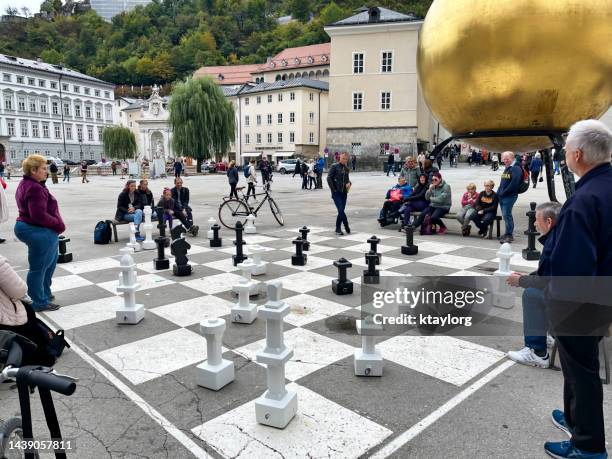 as pessoas se reúnem para ver dois adultos jogarem xadrez na cidade velha de salzburgo - rook - fotografias e filmes do acervo
