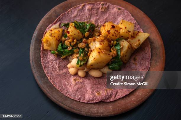 taco de maíz rosa con salteado de lentejas, pak choy, jicama y frijoles blancos (pink maize taco with sauteed lentil, pak choi, jicama and white bean stir-fry) - jicama stock pictures, royalty-free photos & images