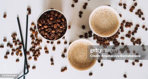 coffee to go in tray on white table with coffee beans and straws - coffee to go becher stock-fotos und bilder