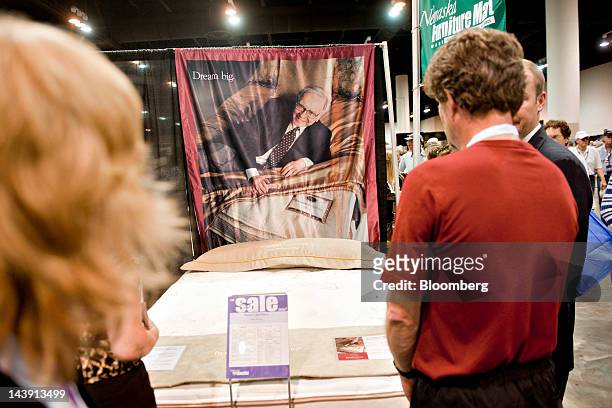 An image of Warren Buffett, chairman of Berkshire Hathaway Inc., hangs above a bedding display during the Berkshire Hathaway annual shareholders...