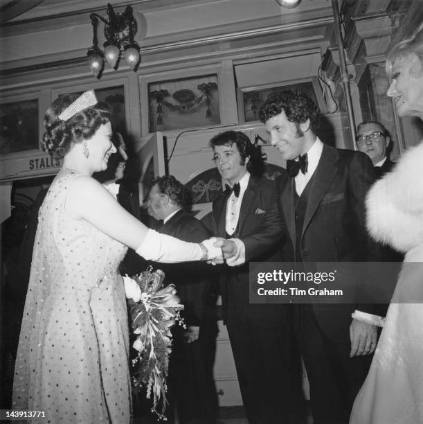 Queen Elizabeth II shakes hands with Welsh singer Tom Jones after the Royal Variety Performance at the London Palladium, 10th November 1969. In the...