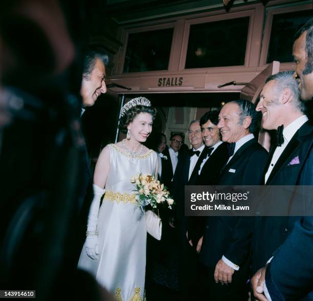 Queen Elizabeth II meets Lovelace Watkins, Bruce Forsyth, Sid James, and Sacha Distel backstage at the Royal Variety Performance, held at the London...