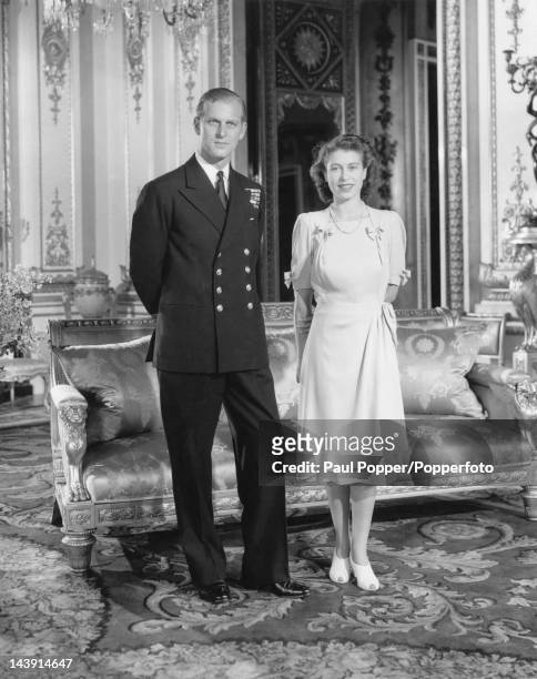 Princess Elizabeth and Lieutenant Philip Mountbatten pose at Buckingham Palace after announcing their engagement, London, 10th July 1947.