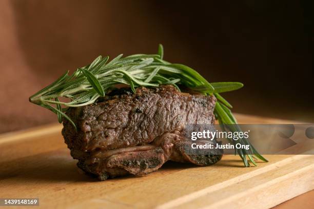 grilled filet mignon beef steak cut with rosemary - t bone steak on the grill stock-fotos und bilder