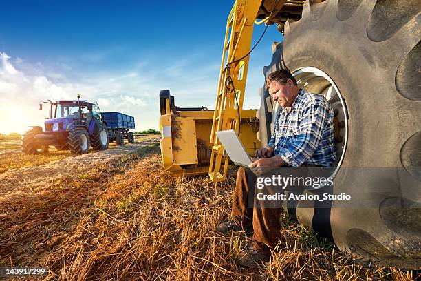 farmer und laptop - landwirtschaftliche maschine stock-fotos und bilder