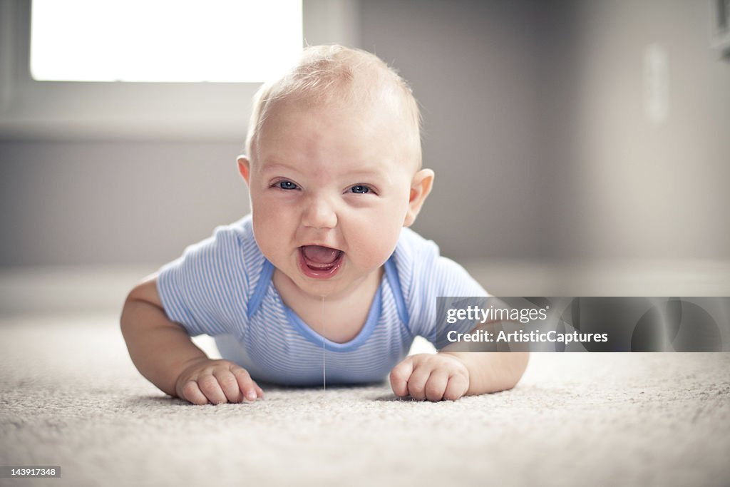 Laughing Baby Boy Lying on Carpet in Home