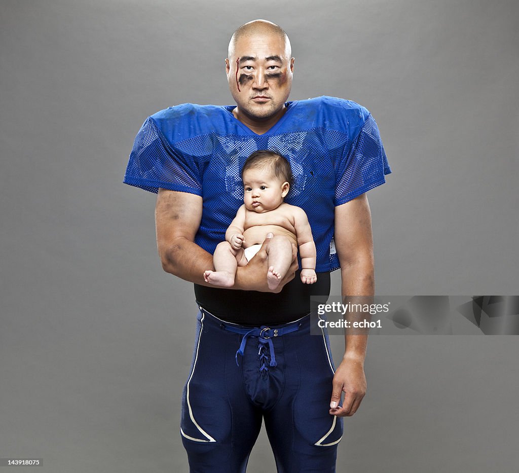 Football player holding baby