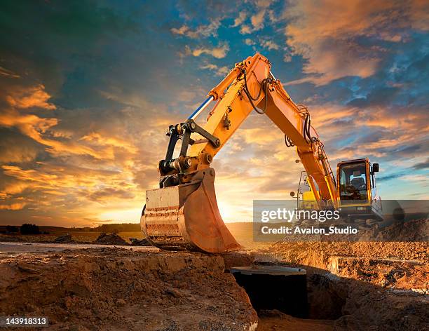 excavator at a construction site against the setting sun. - excavator bildbanksfoton och bilder
