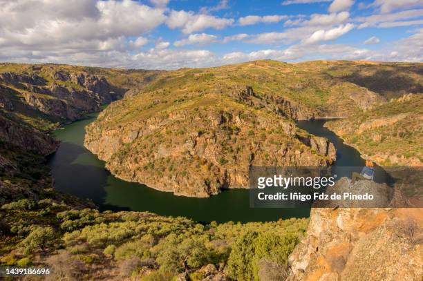 woman sitting on a rock looking at duero river meander, arribes del duero natural park, zamora, spain. - zamora ストックフォトと画像