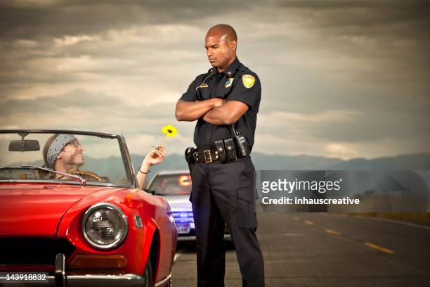 hippy di consegnare fiori a un agente di polizia - good cop foto e immagini stock