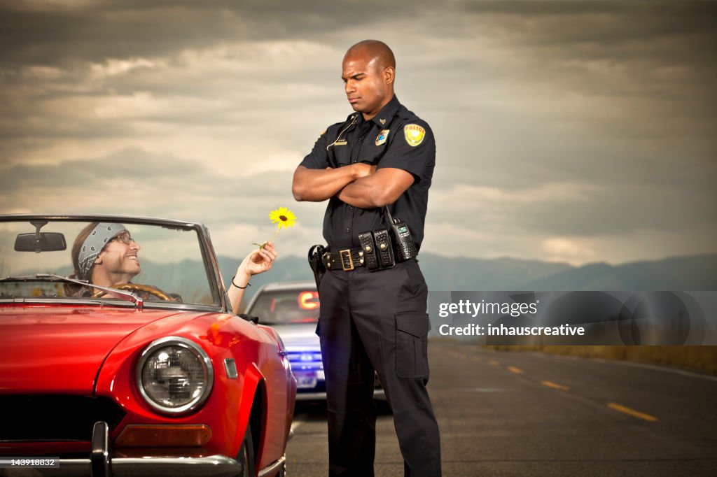 Hippy handing flower to a police officer