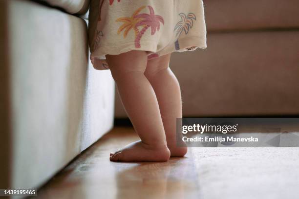 baby girl taking first steps - boy barefoot rear view stockfoto's en -beelden