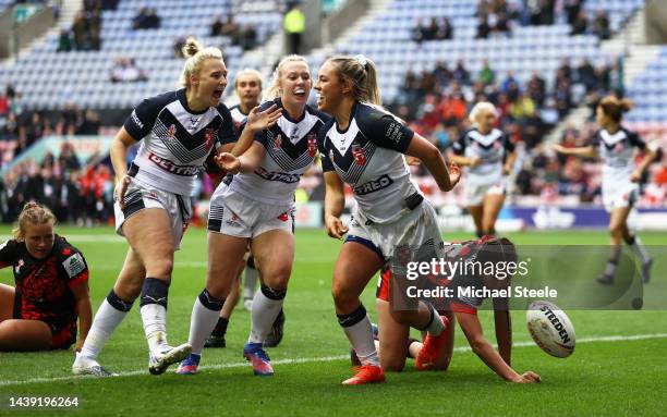 Hollie Dodd of England celebrates their sides second try with team mates during the Women's Rugby League World Cup Group A match between England...