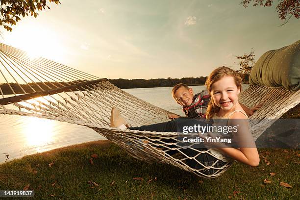 children enjoying hammock by the lake shore in late afternoon - 9 loch stock pictures, royalty-free photos & images