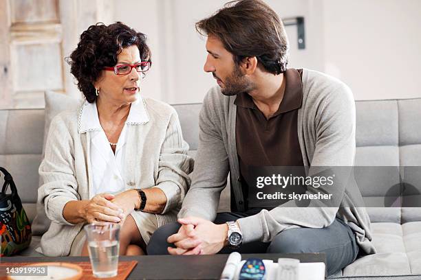 senior adult woman talking to her son. - talking to mom stock pictures, royalty-free photos & images