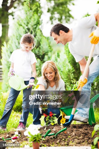 Mather Father And Their Daughter Gardening On Beautiful Day High