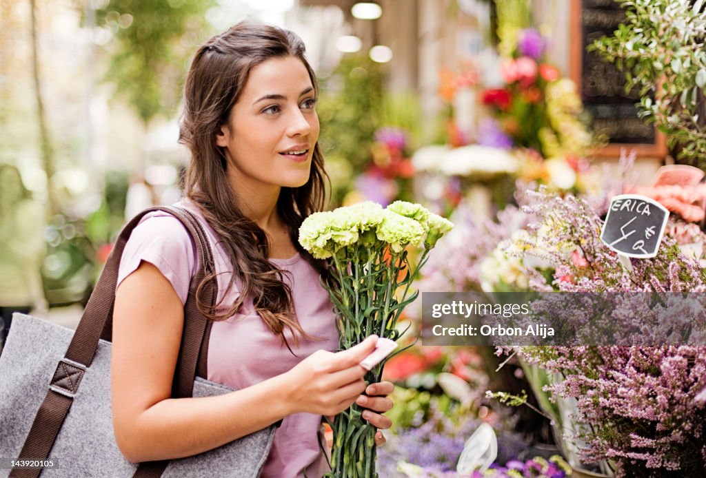 Young women buying flowers at market