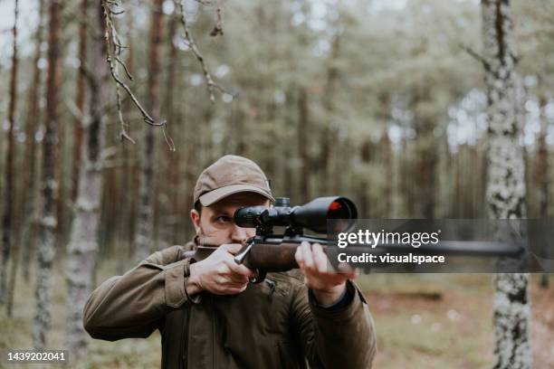 cazador apuntando con rifle de caza en el bosque de otoño - hunting fotografías e imágenes de stock