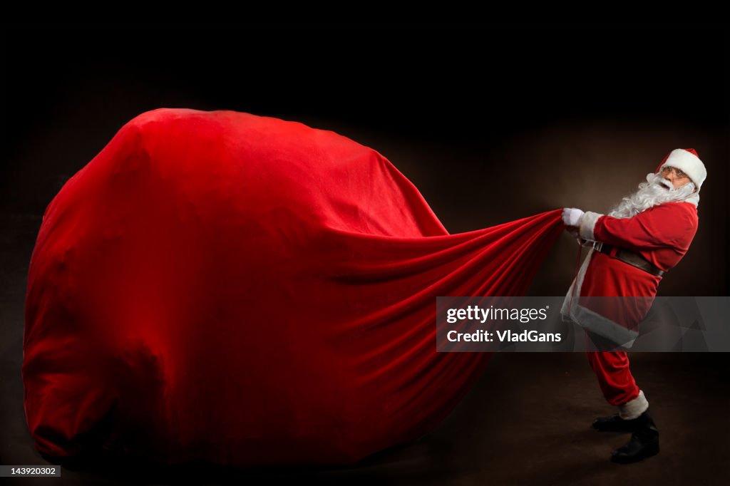 Santa Claus holding a BIG gift bag