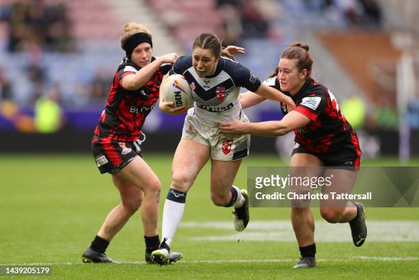 Grace Field of England is tackled by Sabrina McDaid and Maddy Aberg of Canada during the Women's Rugby League World Cup Group A match between England...