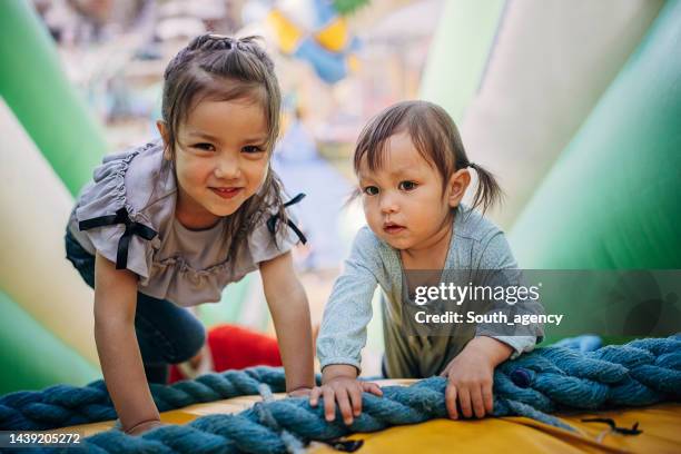 schwestern spielen in hüpfburg - inflatable playground stock-fotos und bilder