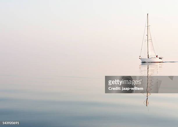 sailing alone at a beautiful foggy sea - jib stockfoto's en -beelden
