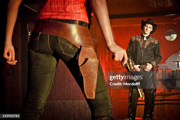 duel! cowgirl with gun opposite cowboy - confrontation stock pictures, royalty-free photos & images