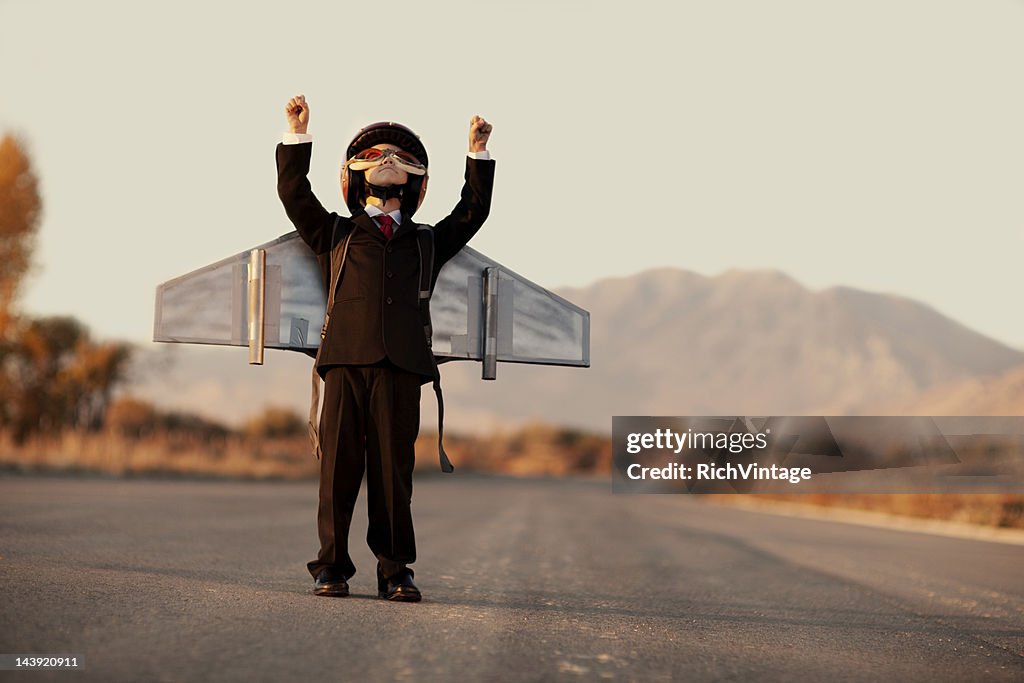 Young Boy Wearing Business Suit and Jet Pack on Blacktop