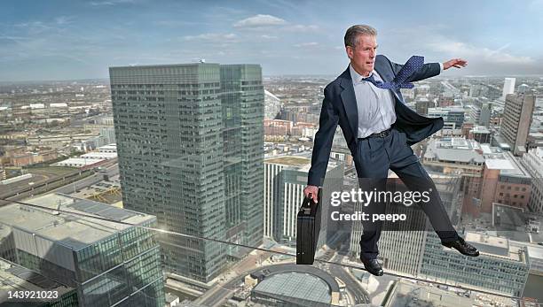 business man on tightrope - tightrope stockfoto's en -beelden