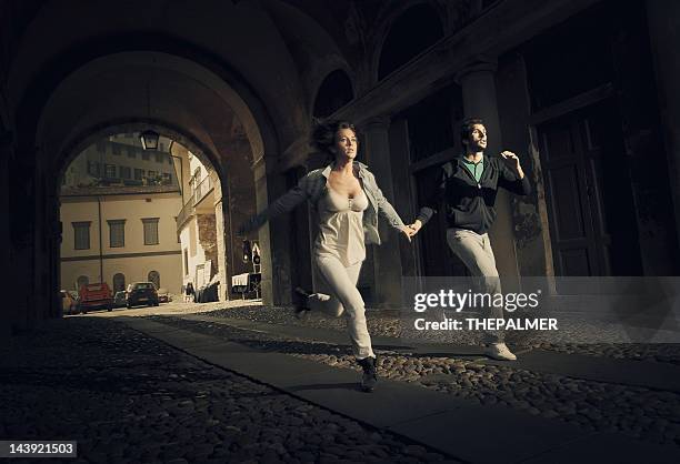 couple running scare - escaping stockfoto's en -beelden