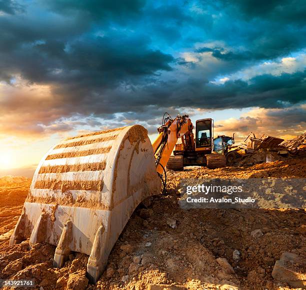 excavator at a construction site against the setting sun - digging machine stock pictures, royalty-free photos & images