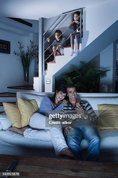 children secretly watching tv after bedtime behind parents back. - step brother stock pictures, royalty-free photos & images