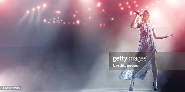 singer performs on floodlit stage - woman spotlight stock pictures, royalty-free photos & images