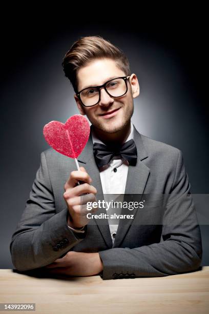 man holding pink heart candy - lolly models stockfoto's en -beelden